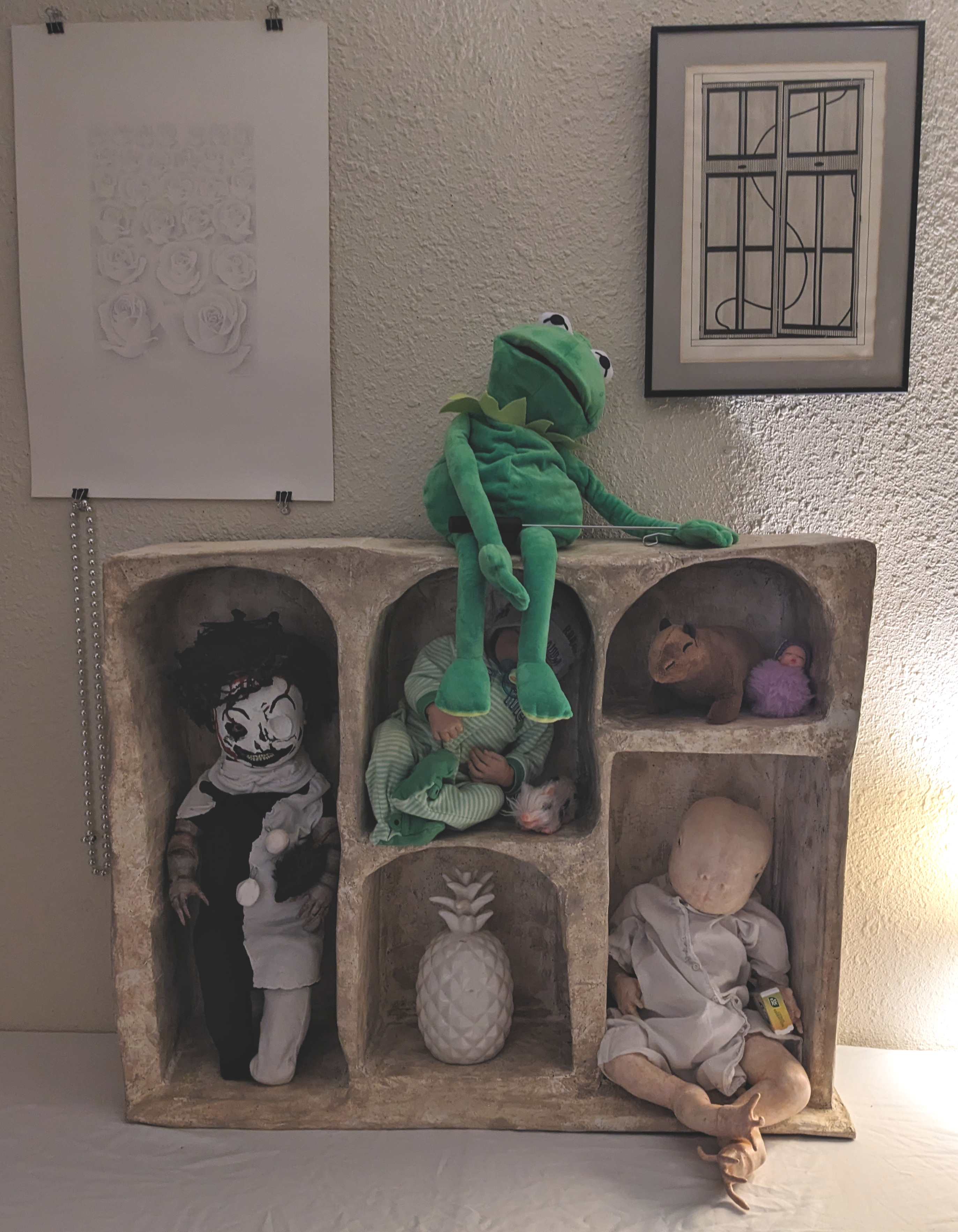 a display shelf with manufactured and custom dolls on it